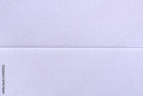 Textural background of white striped cardboard. Texture of white packaging cardboard with a crease in the middle, close-up.