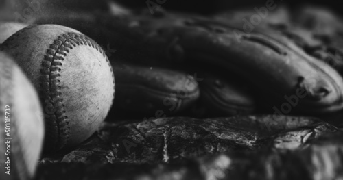 Old vintage baseball game equipment close up in black and white low key lighting.