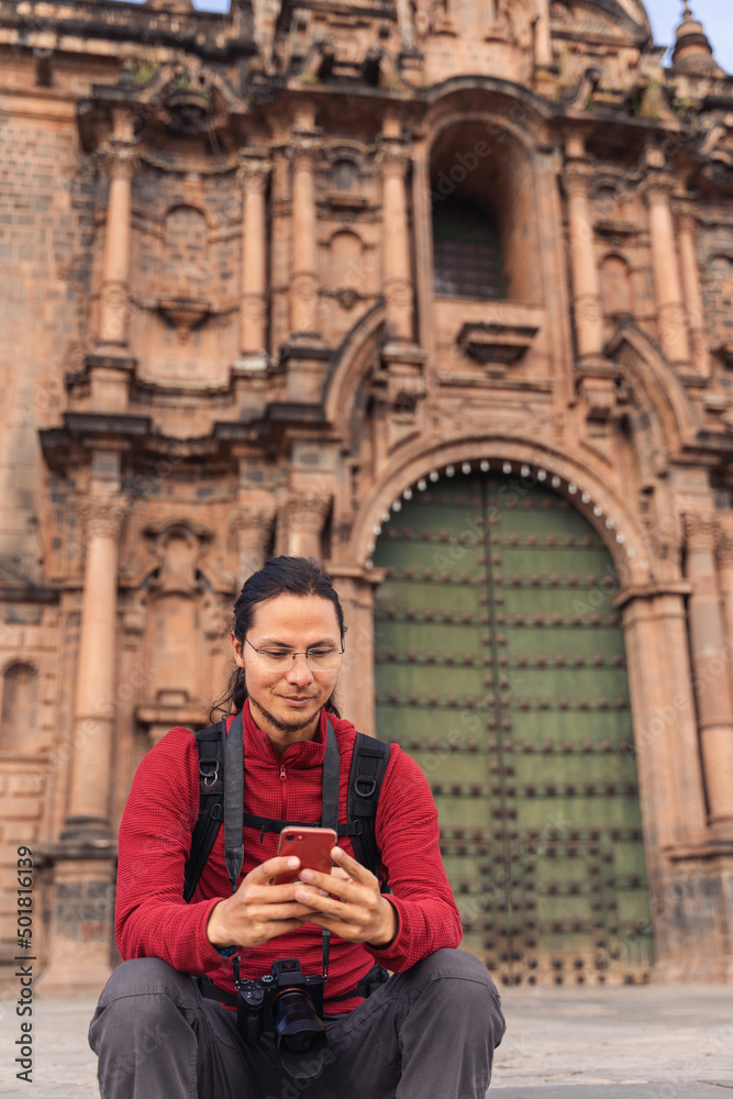 Tourist looking at his cell phone in the main square of Cuzco Tourist looking at his cell phone in the main square of Cuzco