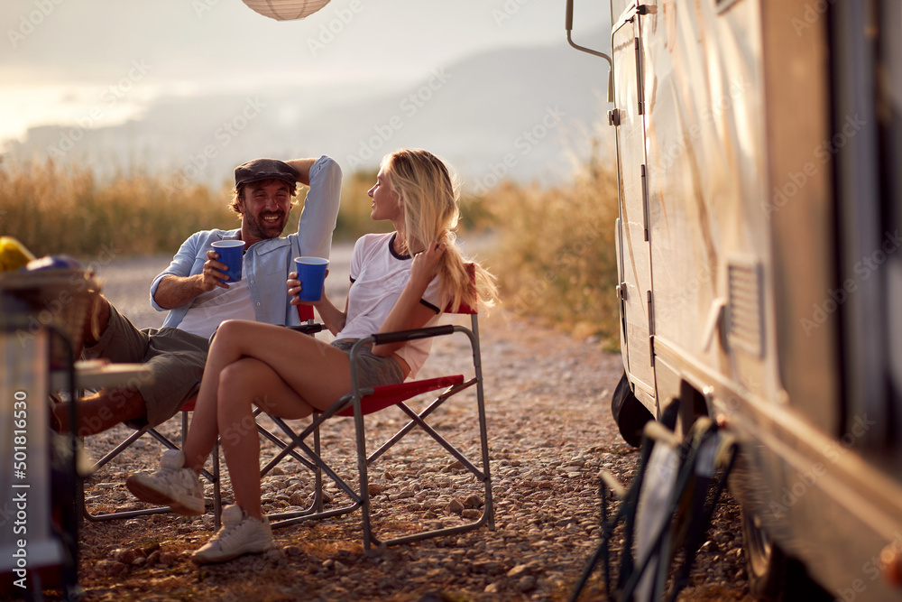 custom made wallpaper toronto digitalCouple at sunset cheering with drinks. Sitting in front of camper rv. Fun, togetherness, travel, nature concept.