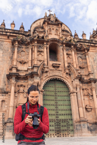 Tourist looking at his camera in the main square of Cuzco.