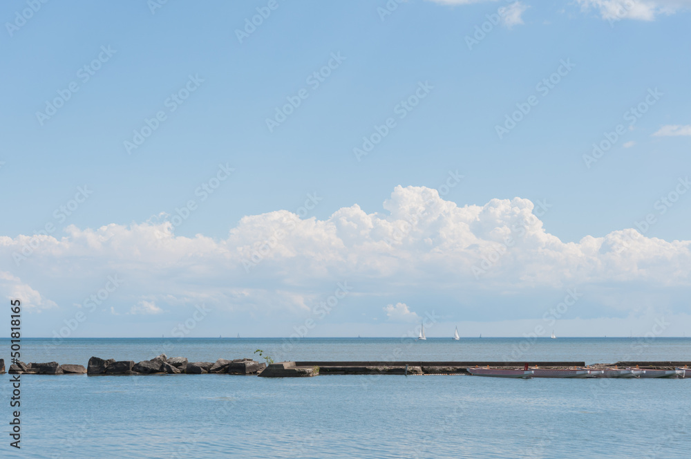 view of distant clouds over the lake (with break water in the foreground)