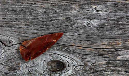 Fotografie One Native American arrowhead on rustic wood