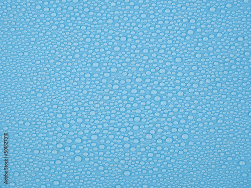 blue background with water drops. water beads on blue background.