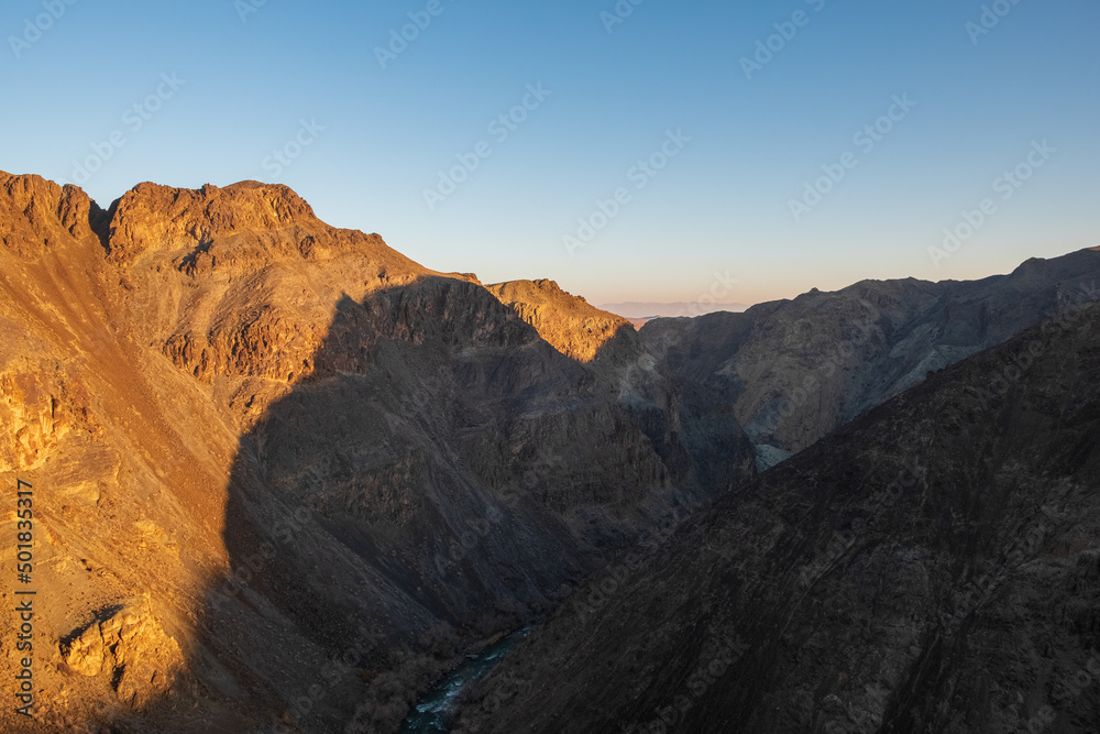 Colorful golden sunset on canyon background. Outdoor landscape. Scenic background. Nature background. Black canyon on Sharyn river in Kazakhstan.