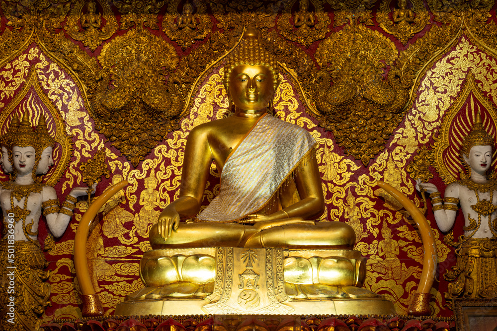 Ancient sculpture of sitting Buddha on the altar of Wat Bupparam Buddhist temple. Chiang Mai, Thailand