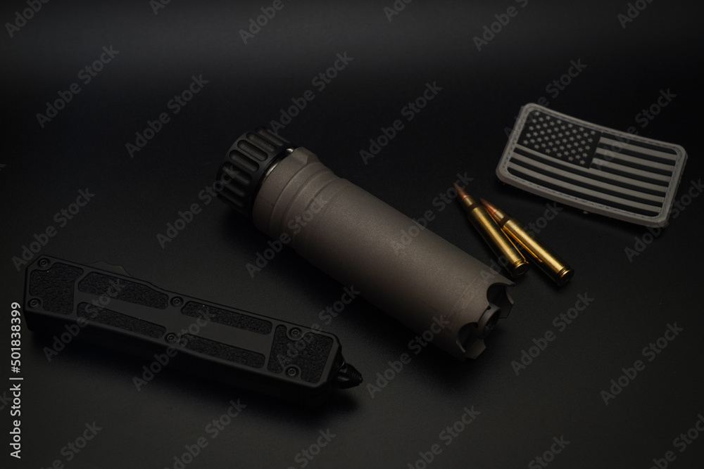Rifle suppressor, tactical knife and usa patch on a black background. Rifle suppressor, tactical knife and usa patch on a black background.