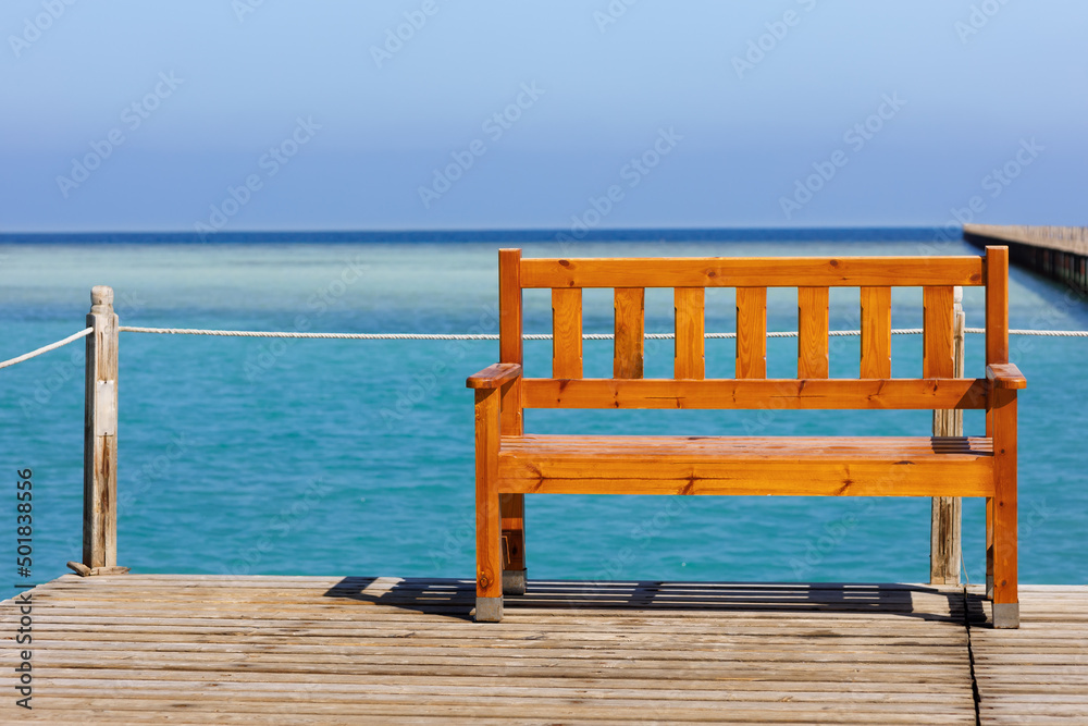 wooden bench on the pontoon overlooking the turquoise sea