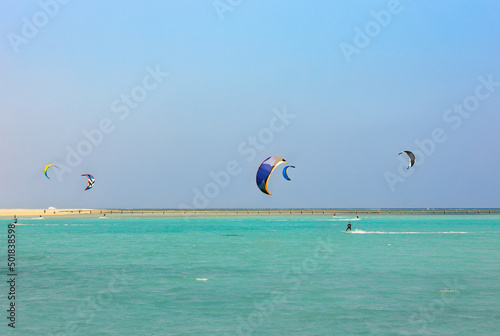 colorful kites for kiteboarding is flying in the blue sky