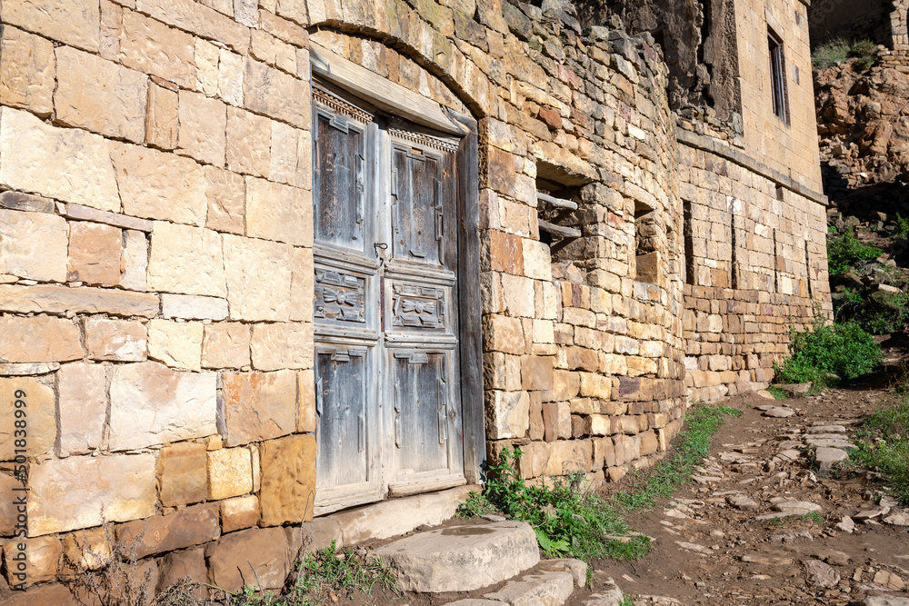 Old door of an abandoned house in the mountain village of Gamsutl on a sunny morning. Republic of Dagestan, Russian Federation Old door of an abandoned house in the mountain village of Gamsutl on a sunny morning. Republic of Dagestan, Russian Federation