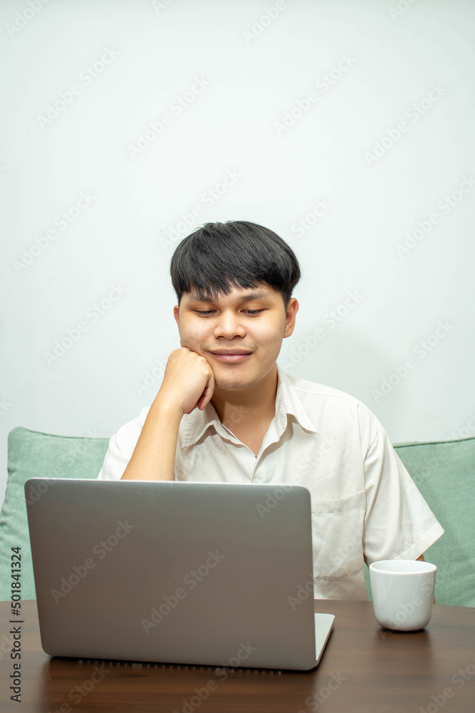 Remote work concept, Male freelancer thinking about business project and working on laptop at home Remote work concept, Male freelancer thinking about business project and working on laptop at home