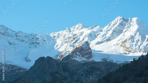 Zoom in shadows  moving sunrise time lapse very beautiful nature of mountain peaks, Kazbek mountain , Northern Ossetia - Alania, Dargavs, Caucasus, Russia , moving clouds
