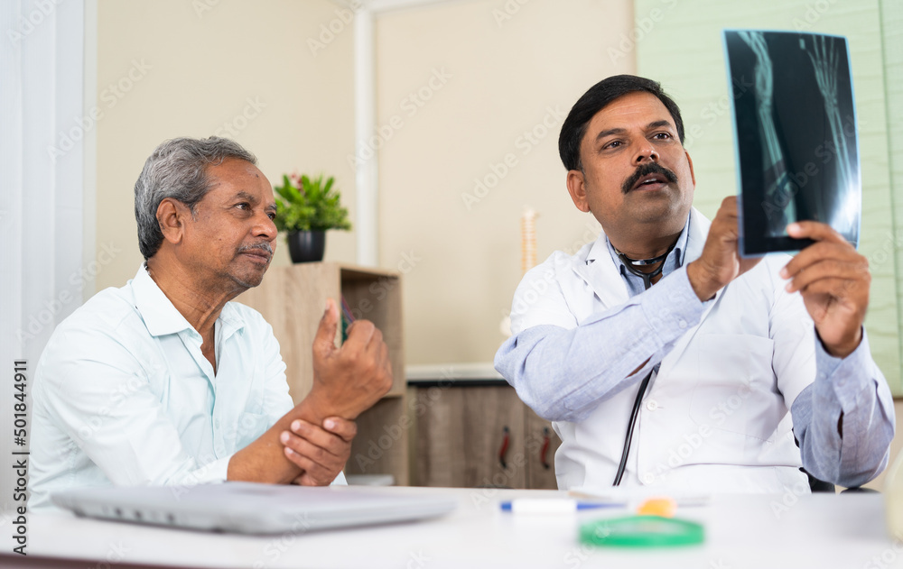 doctor explaining by seeing x-ray report to senior elderly patient at hospital - concep tof medical treatment, assistance and Healthcare doctor explaining by seeing x-ray report to senior elderly patient at hospital - concep tof medical treatment, assistance and Healthcare