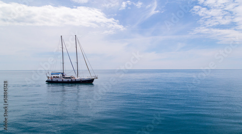 Sailboat sailing in the morning with blue cloudy sky. Luxury yacht in open waters with beautiful clouds © Anatoly
