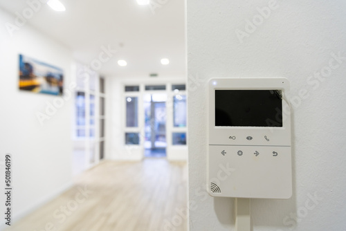 Concept of home automation smart modern luxury wealthy home. On white wall home security alarm and video intercom with street view talkback or doorphone voice communications system close up, no people photo
