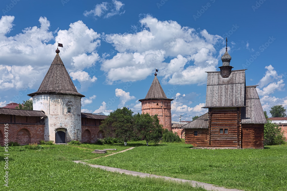 Yuryev-Polsky, Russia. Towers of fortified wall of Archangel Michael Monastery, and wooden church of St. George. The monastery was founded in the 13th century. The church was built in 1718.
