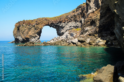 Natural volcanic arch formed from lava on the crystal clear tyrrhenian sea in Punta Perciato, Pollara, Salina. Rocky coastline, Aeolian Islands Archipelago, Sicily, Italy.
 photo
