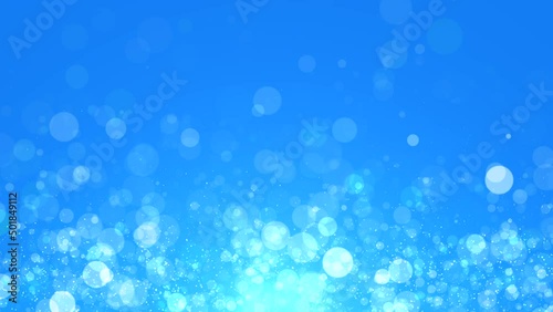 Abstract glowing sphere particles moving up at shining blue light background. Seamless loopable background.