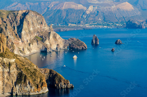 Stunning view of Valle Muria beach in Lipari and the Faraglioni. In the background the crater of Vulcano Island. Aeolian islands, Sicily
 photo