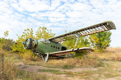 The destroyed and plundered wreckage of the Soviet AN2 aircraft stored in the bushes of the old airfield in Volchansk. Soviet aviation. Training aircraft.