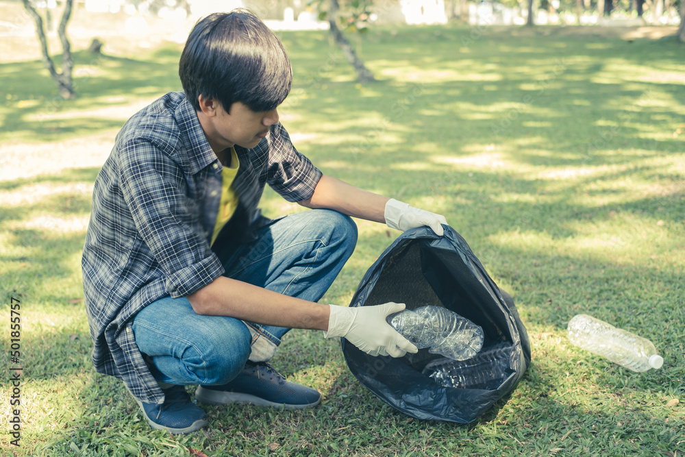 young Asian men, garbage collection pick up plastic bottles, put garbage in black garbage bags to clean up at parks, avoid pollution, be friendly to the environment and ecosystem young Asian men, garbage collection pick up plastic bottles, put garbage in black garbage bags to clean up at parks, avoid pollution, be friendly to the environment and ecosystem