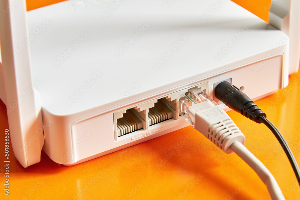 White wireless router on orange background connected by cable to the  Internet. Close-up Stock Photo | Adobe Stock