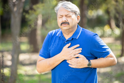 Senior indian man having chest pain outdoor, heat attach, cardiac arrest, Health care and fitness, Mature adult cardiology. problem.
