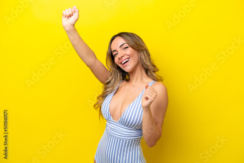Young caucasian woman isolated on yellow background in swimsuit in summer holidays