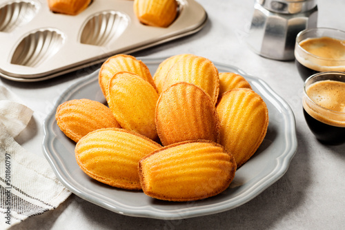 Perfect French madeleine cookies, buttery and delicate, served with cup of coffee. Light gray background. photo