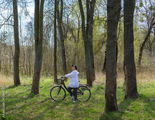 Woman cycling in the forest on a sunny summer day.