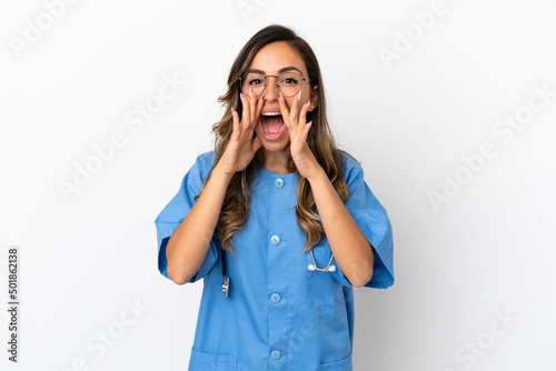 Young surgeon doctor woman over isolated white wall shouting and announcing something