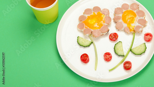 Sunny-side-up eggs with sausage for kids on colourfull background.