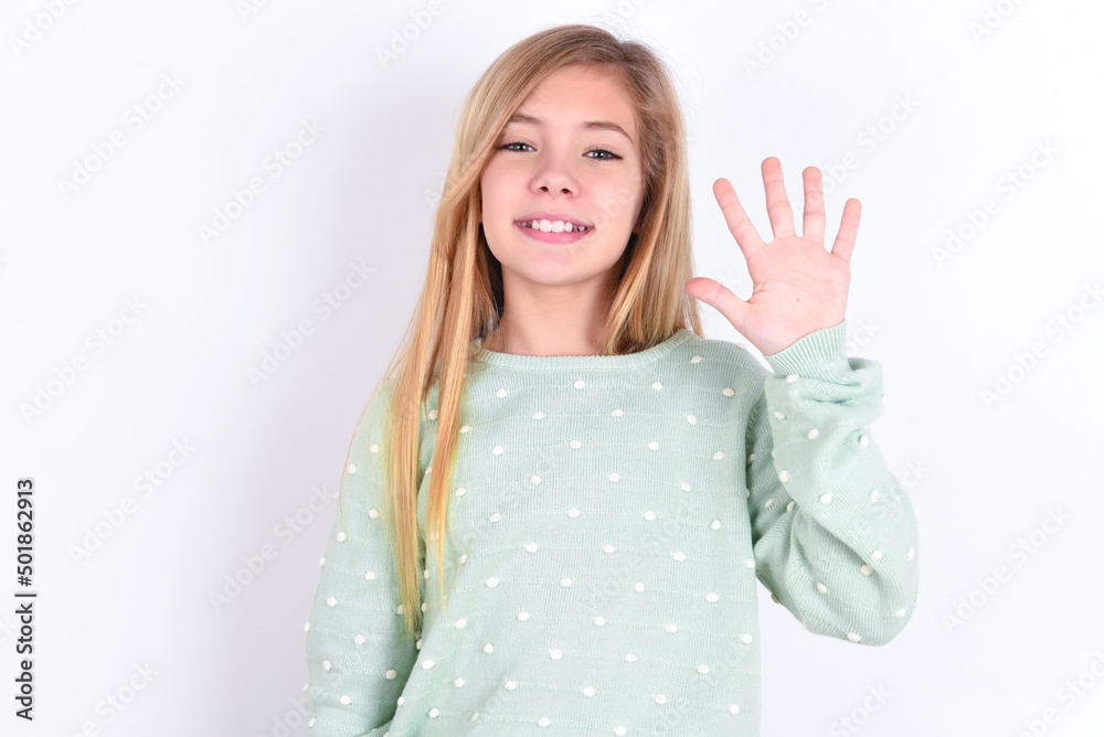 little caucasian kid girl wearing fashion sweater over blue background showing and pointing up with fingers number five while smiling confident and happy.