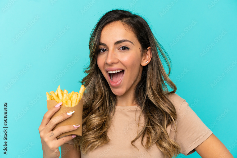 Young woman holding fried chips over isolated background Young woman holding fried chips over isolated background
