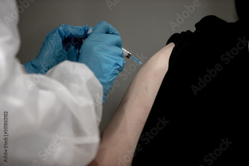 close up doctor holding syringe and using cotton before make injection to patient in medical mask. Covid-19 or coronavirus vaccine
