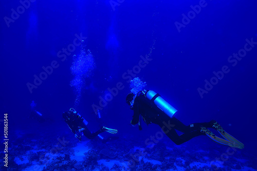 divers underwater at depth in the blue sea background