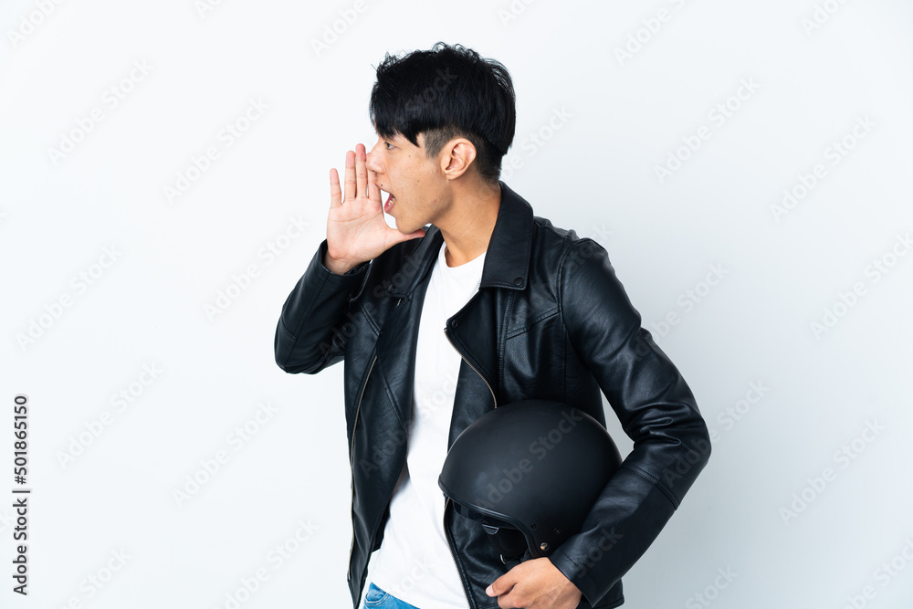 Chinese man with a motorcycle helmet isolated on white background shouting with mouth wide open to the side Chinese man with a motorcycle helmet isolated on white background shouting with mouth wide open to the side