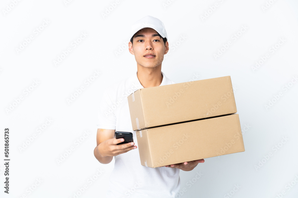 Delivery Chinese man isolated on white background sending a message with the mobile Delivery Chinese man isolated on white background sending a message with the mobile
