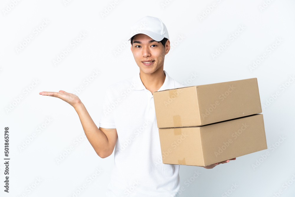 Delivery Chinese man isolated on white background holding copyspace imaginary on the palm to insert an ad Delivery Chinese man isolated on white background holding copyspace imaginary on the palm to insert an ad