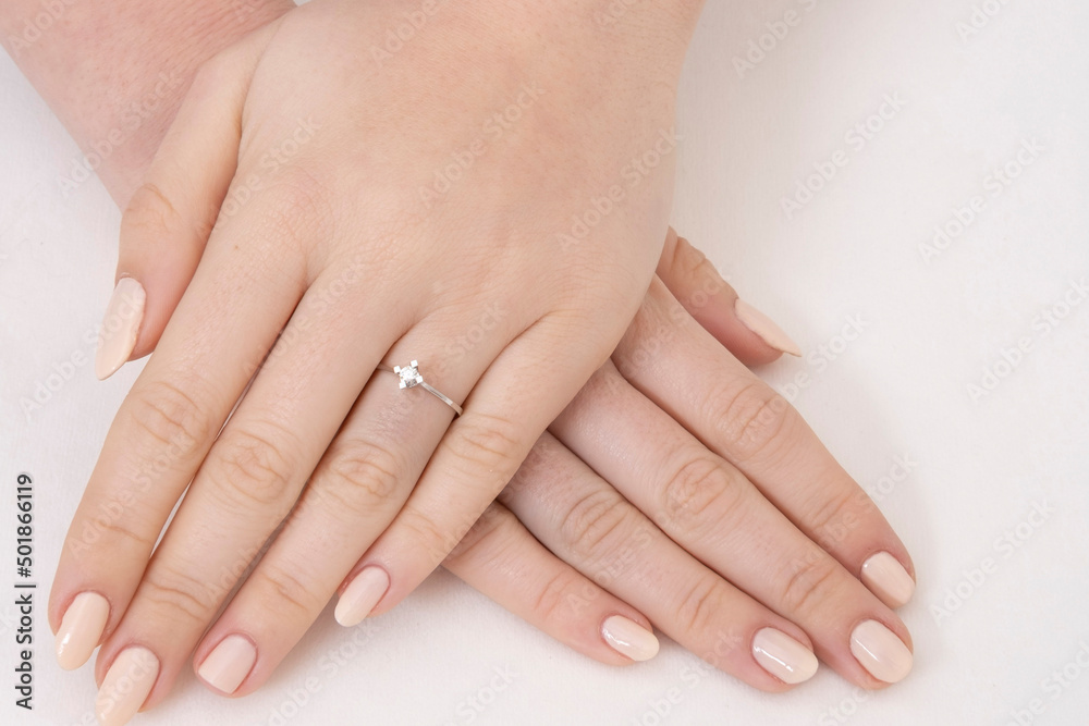 Golden Ring on a female hand, diamonds Diamond ring in hands of young lady. Close-up photo shoot Golden Ring on a female hand, diamonds Diamond ring in hands of young lady. Close-up photo shoot