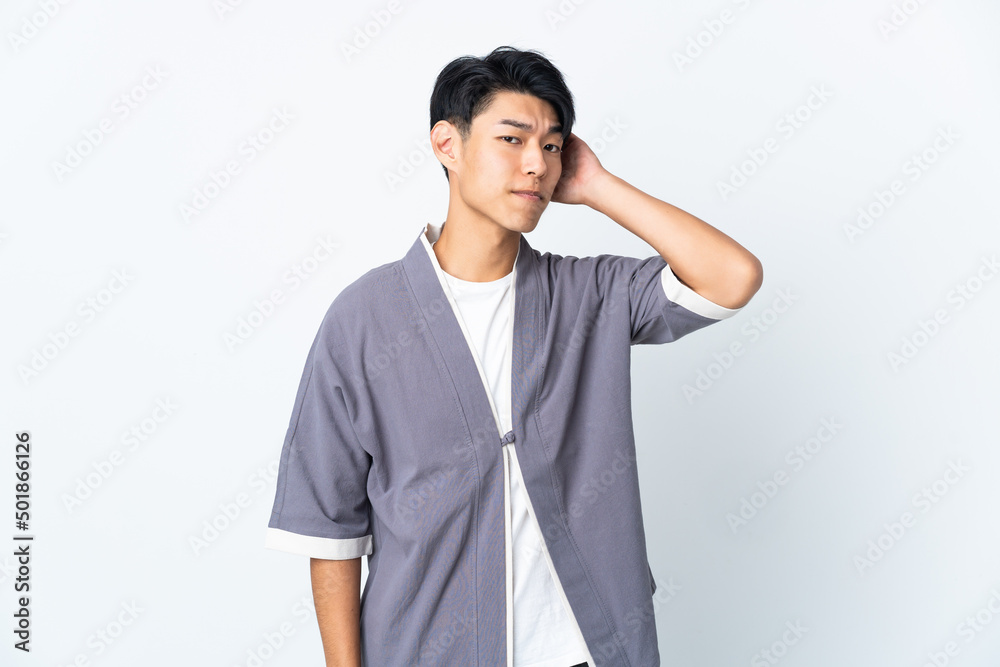 Young Chinese man isolated on white background having doubts Young Chinese man isolated on white background having doubts