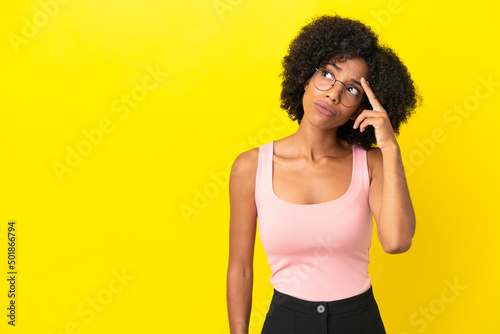 Young African American woman isolated on yellow background with problems making suicide gesture © luismolinero