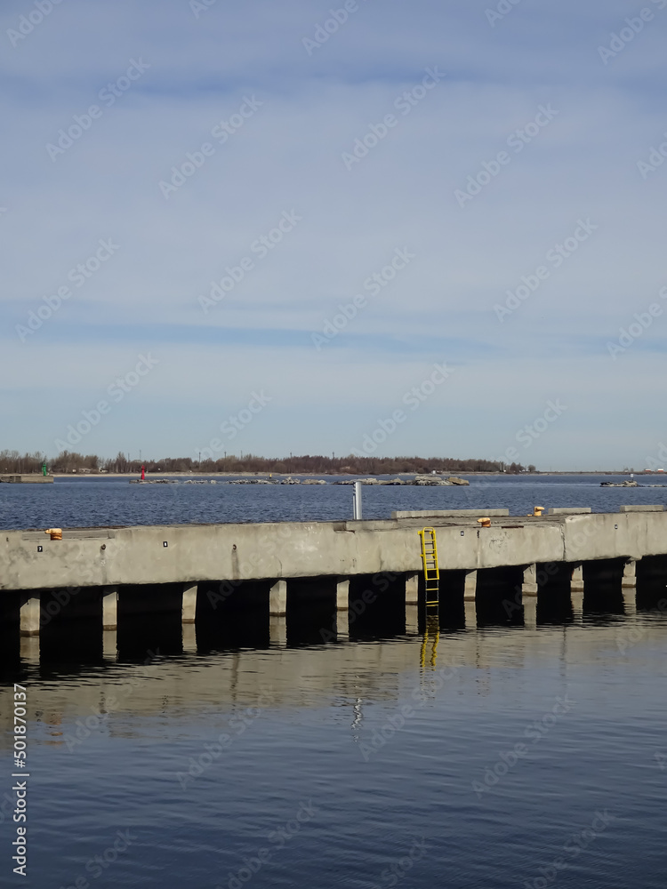 Seaview with stone, concrete pier in Noblessner on sunny morning. Yellow stair. Tallinn, Estonia, Europe. April 2022