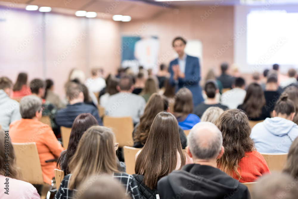 Business speaker giving a talk at business conference event.