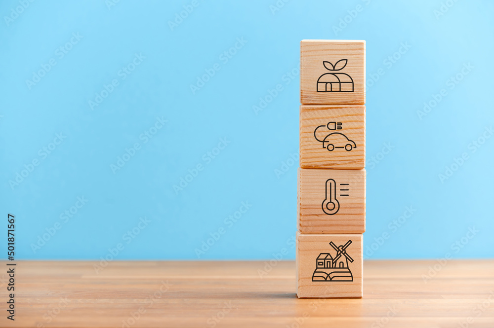 Wooden blocks with environmental symbols. Circular economy concept. Business and environment sustainable. Limited climate changing. Eco infinity and carbon emissions icon on blue backgound.