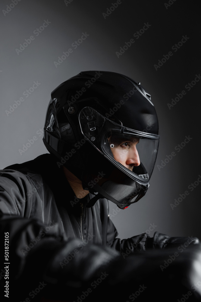 Motorcyclist on his bike wearing helmet riding motorcycle indoors.