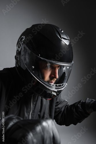 Biker in the helmet close up portrait, riding motorcycle, studio shot