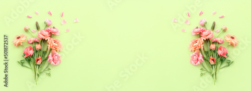 Top view image of pink flowers composition over green wooden background