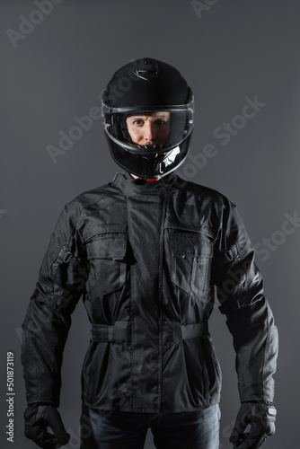 Studio shot of Motorcyclist biker in black equipment looking at camera. © BASILICOSTUDIO STOCK