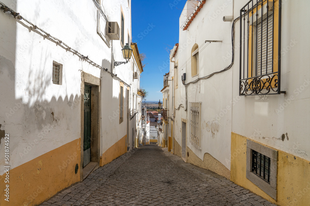 Street in the old town of the fortified city of Elvas (World Heritage Site by UNESCO) with its traditional white facades. Alentejo region, Portugal.